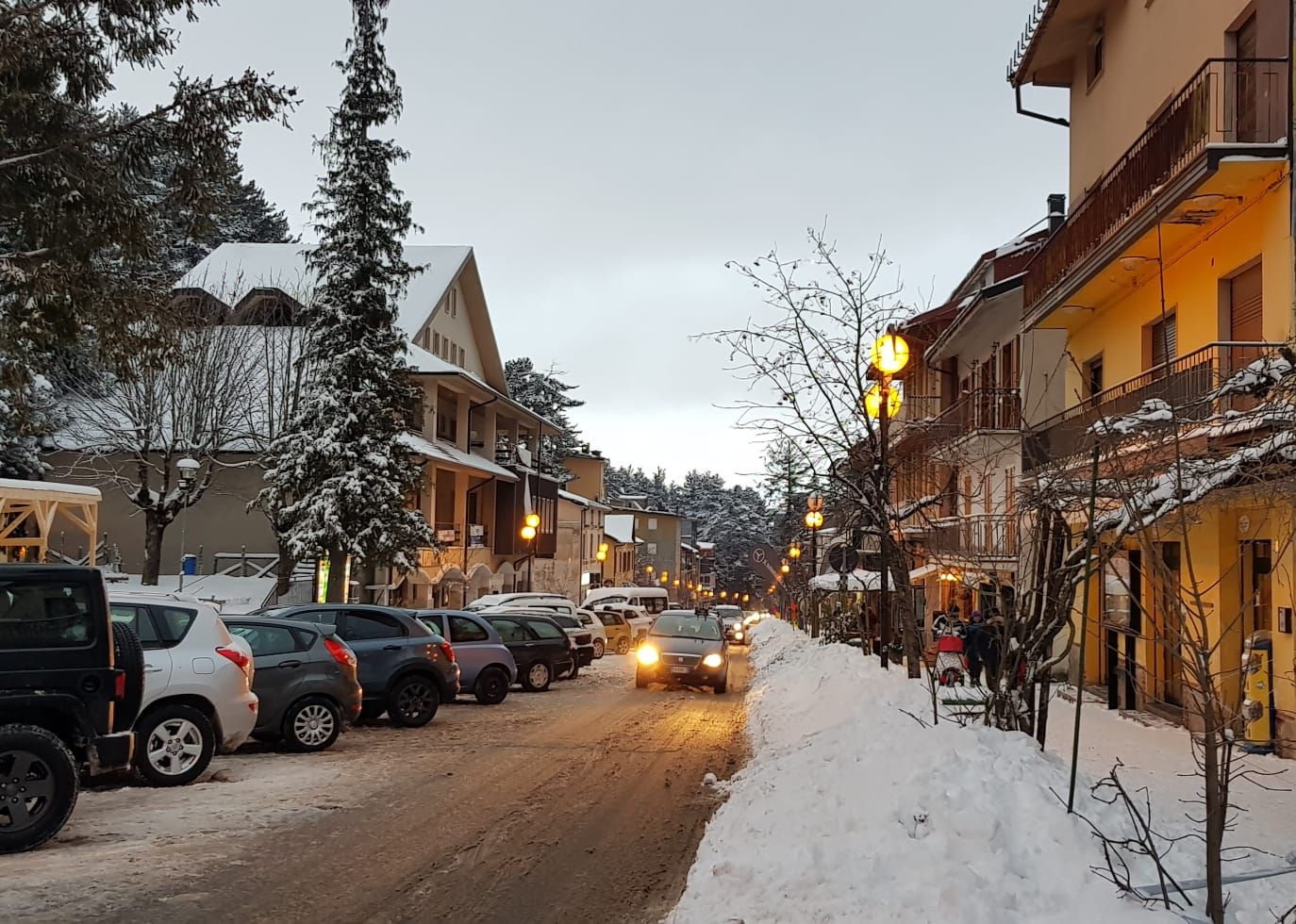 La via centrale di Camigliatello Silano innevata, con le luci accese